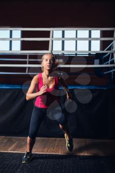 Young girl doing aerobics near boxing ring