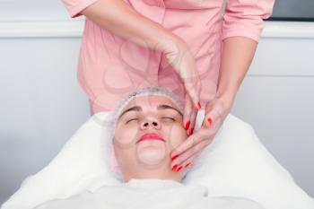 Young woman getting spa treatment at beauty salon. Spa therapy. Face Massage. Facial treatment. Skin and body care.