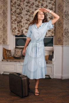 Young woman get ready on a journey. Retro style suitable for travel concept.