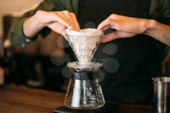 Closeup of male hands  prepares coffee pot standing on bar counter.
