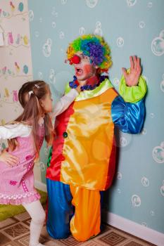 Cruel girl playing with scared clown at her birthday party