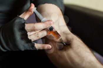 Addict hands making syringe injection of heroin. Hard drugs abuse addict people.