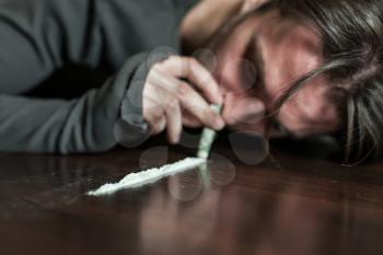 Addict in depression smells cocaine trace. Abuse of drugs leads to a depression.