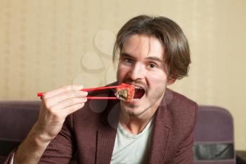 Businessman eat sushi with chopsticks. Traditional japanese food.
