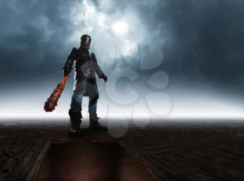 Bottom view of serial killer in hockey mask and black leather coat with bloody baseball bat with a chain wrapped around against dark sky on background.