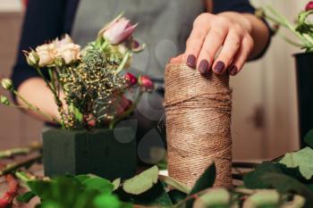 Florist at work: Woman creating modern bouquet of different flowers.