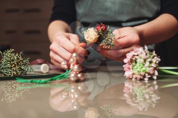 Female florist creating bouquet decoration in flower shop closeup. 