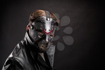 Bloody murderer in hockey mask portrait on black background