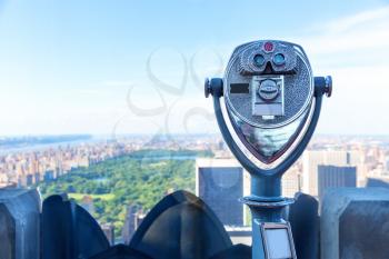 Observation deck view against coin operated binocular. Blur city on background.