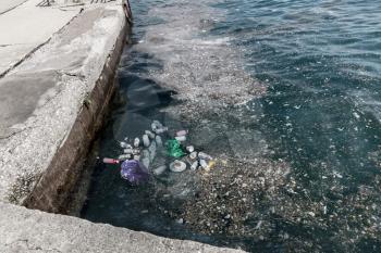 Garbage in water on pier. Danger ecology environment.