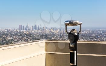 Coin operated binocular against blur city on background. Tourist observation deck.