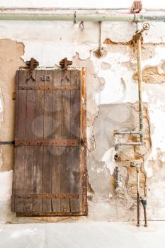 Inside old prison. Wooden door of prison cell with number.