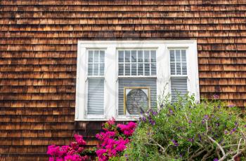 House in retro style with wooden window and garden flowers.