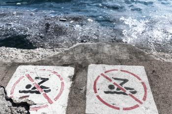 Danger ecology environment. No swimming sign on coast.