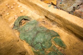Archeological excavations of the human mummy wrapped in a green rag.