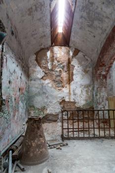 Jail interior with grunge rusty cell and brick walls