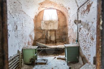 Jail interior with grunge rusty cell and brick walls