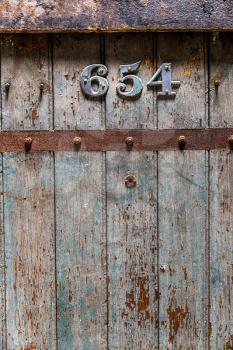 Wooden old prison door closeup. Jail door with number 654