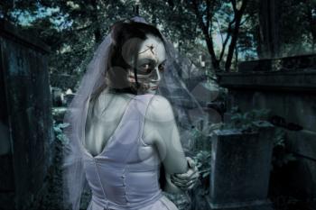 Young dead bride against the background of the night cemetery