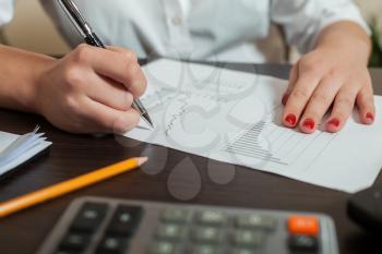 Bookkeeper signs accounting balance sheet. Accountant hands closeup