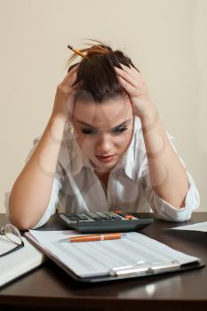 Frightened accountant looks at the accounting balance sheet.