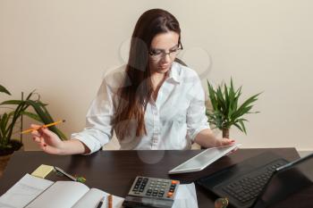 Female bookkeeper hands holding tablet pc. Table with laptop on background