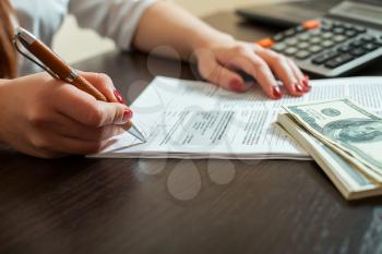 Woman bookkeeper signs accounting documents. Businesswoman concept.