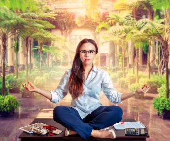Female bookkeeper yoga meditation on the table, green botanical garden on background