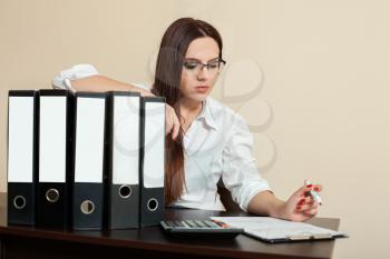 Young female accountant hugs documents folders in office