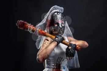 Serial murederer in wedding dress with bloody bat. Bride in hockey mask
