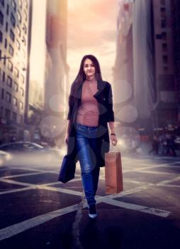 Attractive woman with shopping bags crossing a city street