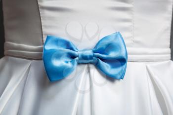 Blue bow on white wedding dress closeup