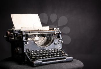 Antique grunge typewrite with inserted paper sheet isolated on black background. Old type writer concept