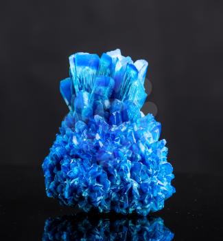 Blue salt crystal isolated on black background. Icy sulphate