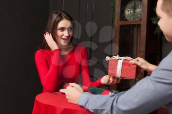 Attractive gift to a beautiful woman in luxury restaurant. Love couple, romantic date