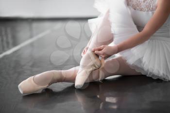 Ballet dancer legs in pointe shoes closeup. Ballerina rehearsal in class