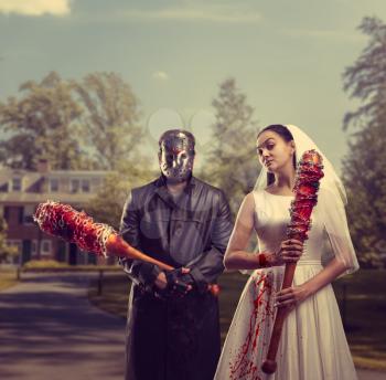 Bride and groom in hockey mask holding bloody bats in their hands. Maniac family