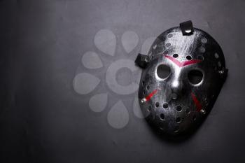 Hockey mask of serial killer with bloody strips isolated on black background. Murder horror