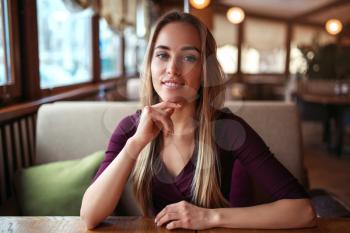 Young woman in a cafe or restaurant. Female waiting in cafe.