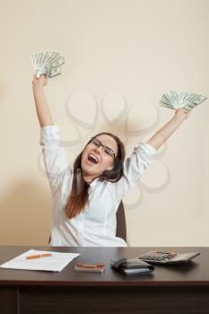 Smiling businesswoman throws up a pack of dollars and make money rain.