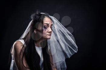 Bride with tearful face, unhappy marriage. Studio photo shoot on black background