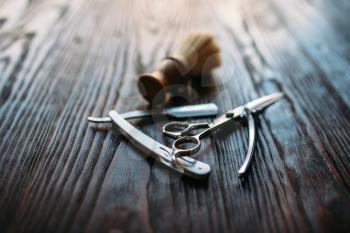 Shaving and barber shop equipment on wooden background, closeup
