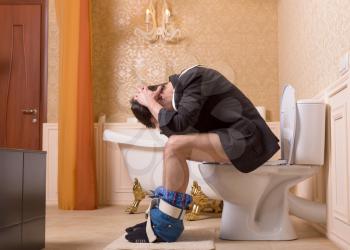 Diarrhea or constipation problem concept. Man with pants down sitting on the toilet bowl