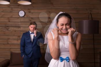 Happy bride against groom talking on the phone, wooden background.