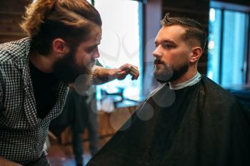 Barber styling mustache and beard at the barbershop. Hairdressing concept