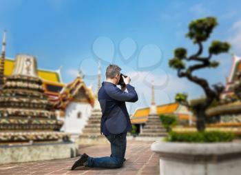 Male camerist taking picture of the temple on digital camera