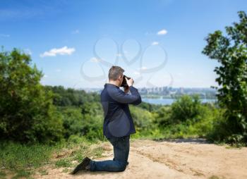Male photographer taking picture of cityscape on digital camera