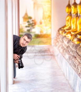 Professional photographer with digital camera in Buddha temple