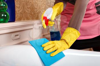 Female person hands in rubber gloves cleans sanitary equipment. Housekeeping concept