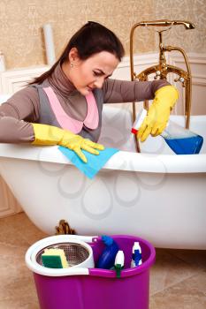 Female worker in cleaning servisce uniform sitting in bath. Housekeeping concept